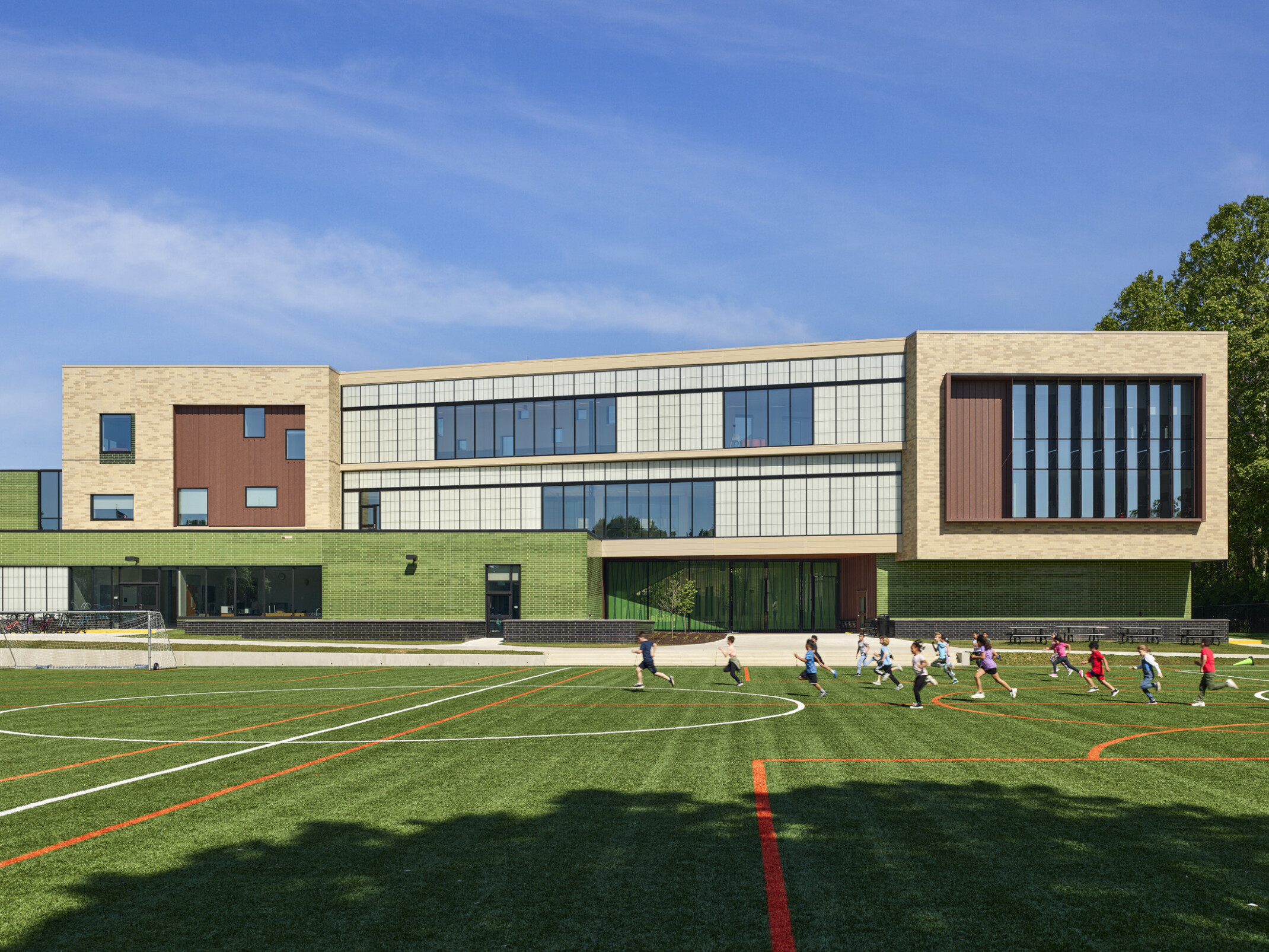 Rendering of a modern multistory elementary school with a soccer field in front