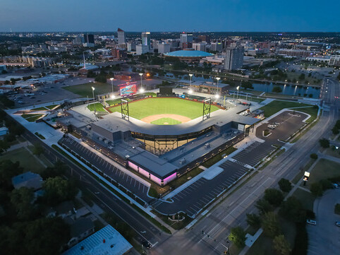 Aerial view of the stadium lit up at dusk within the downtown skyline.