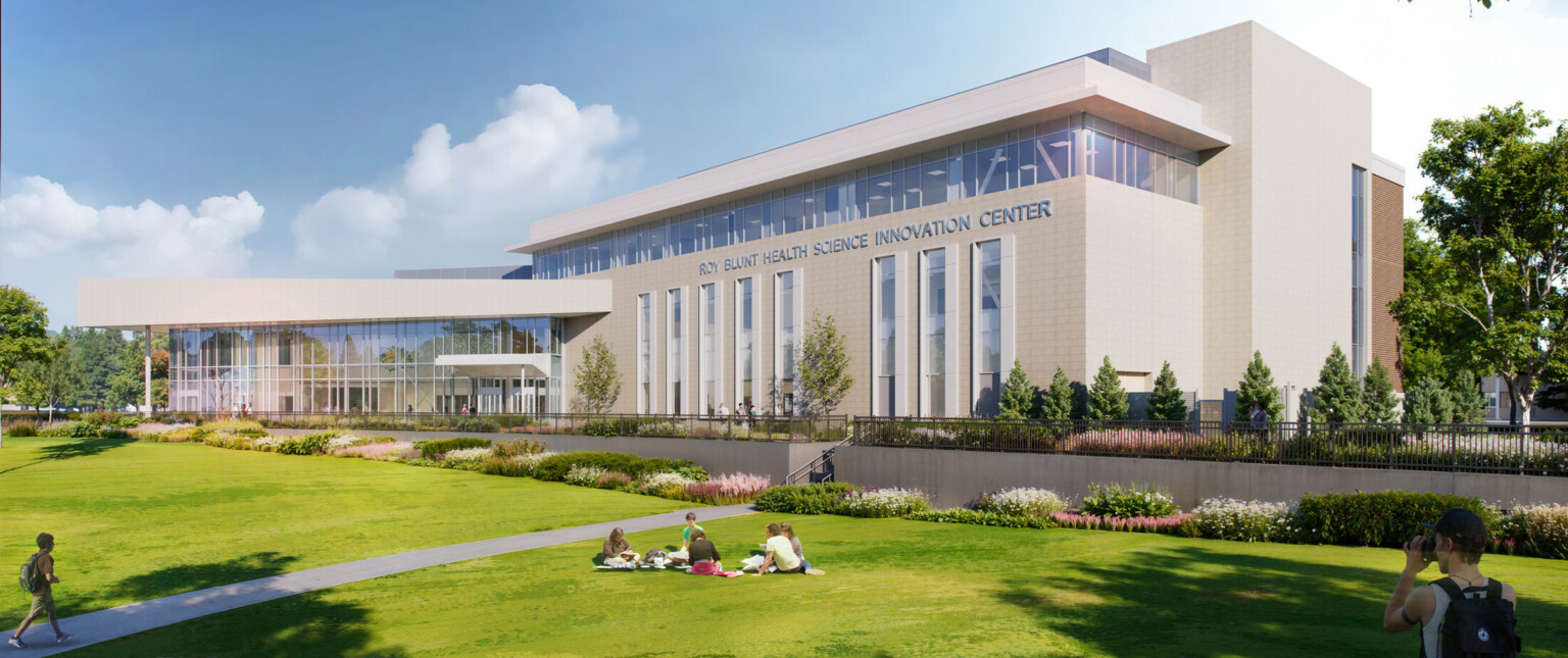 The Roy Blunt Health Science Innovation Center. Modern building with large glass windows, surrounded by lush greenery and a spacious lawn.