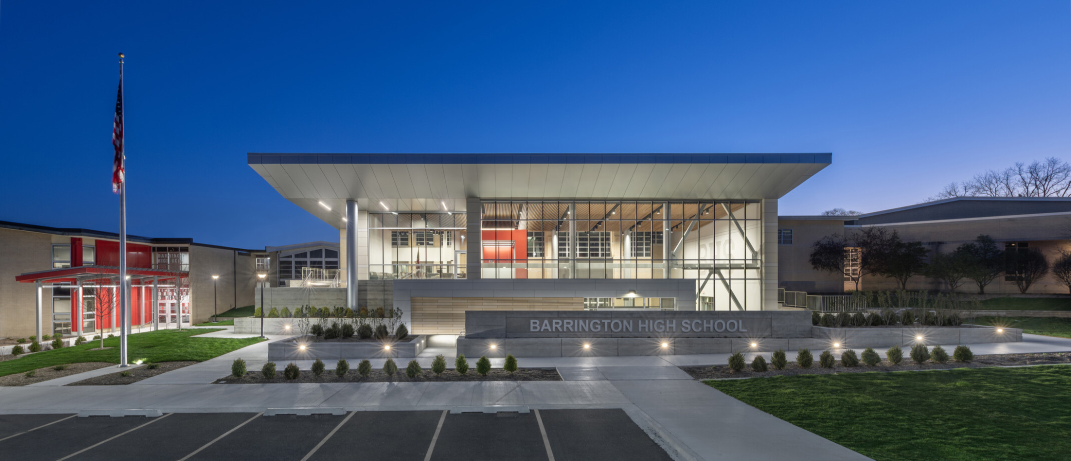 Exterior of Barrington High School showing a multistory building with lit up windows