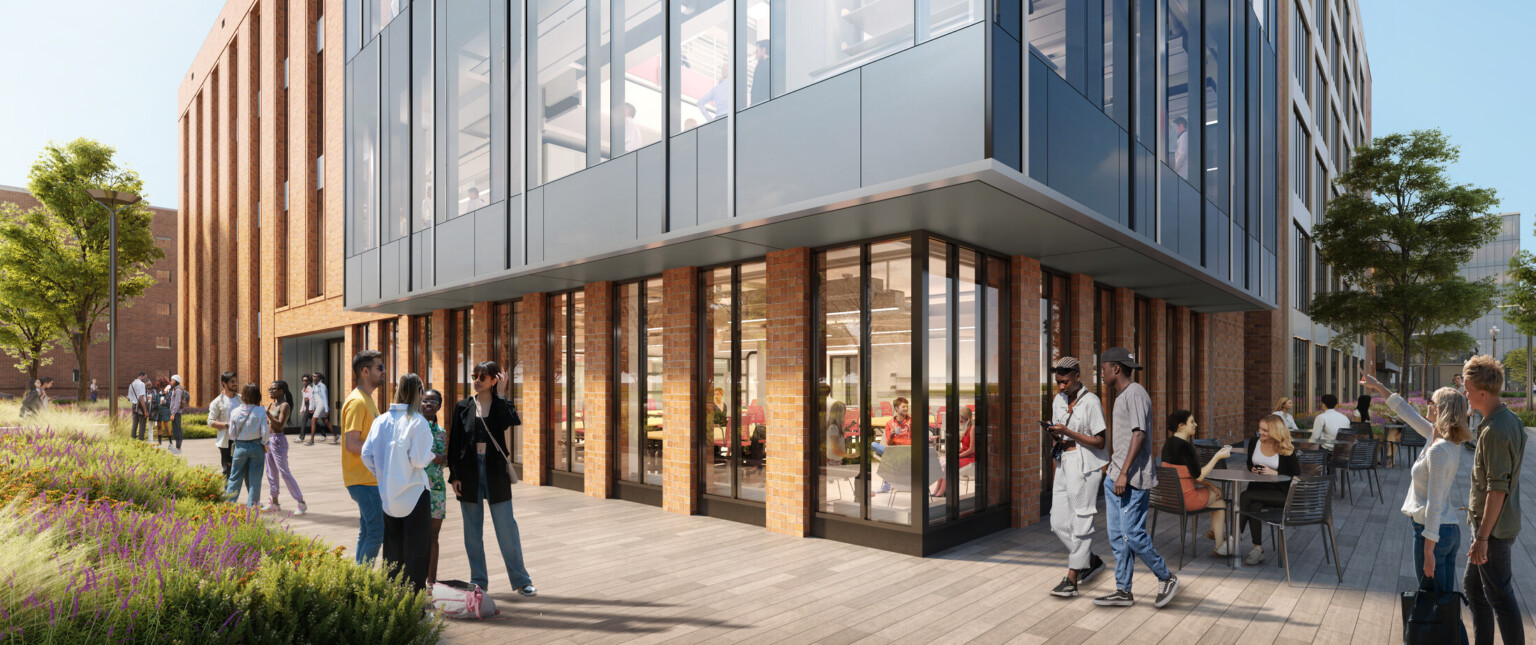 Multi story brick and glass wrapped facade building at corner view, transparent access to engineering stem facility for public