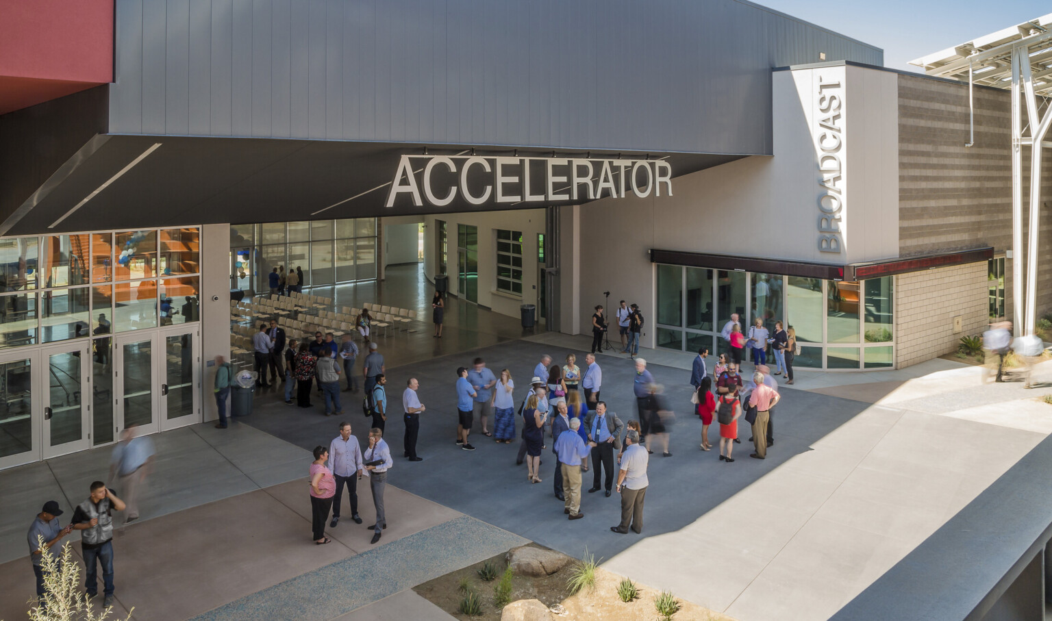 Section of building labeled Accelerator has an angled black roof above wall opening up a seating area to the patio