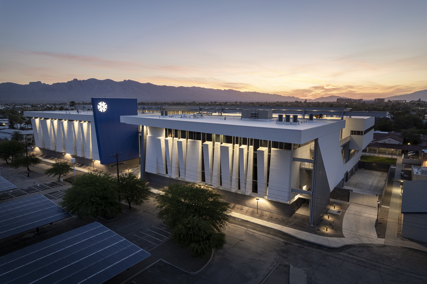 night view of pima community college, vertical lights illuminate the perforated facade