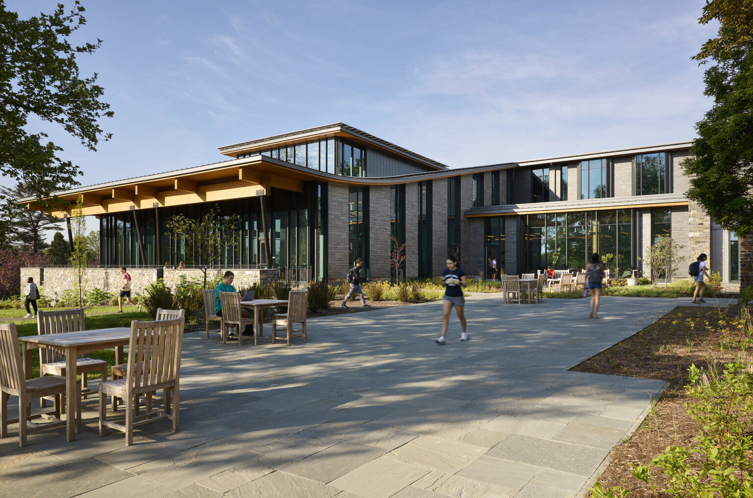 Walkway to swarthmore dining facility, students sitting around exterior flexible seating, mass timber architecture, what is mass timber construction