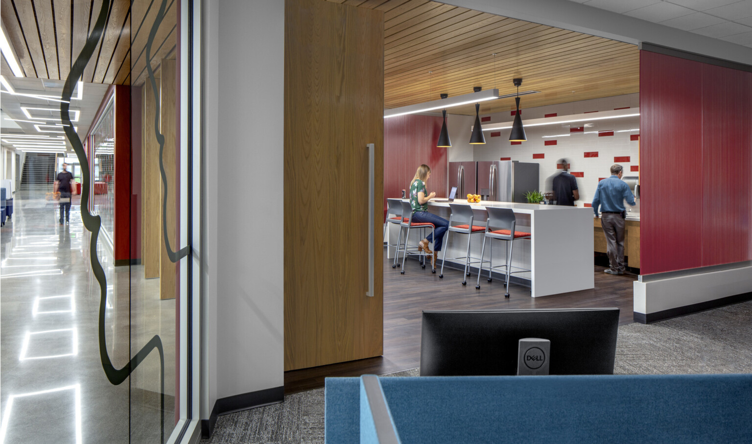 workplace breakroom with red and white tile backsplash with a white counter and multiple high chairs