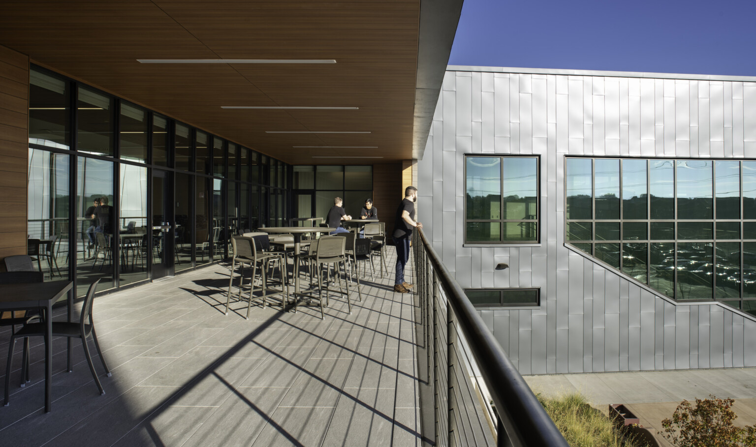 Second story balcony filled with table and chairs overlooking a courtyard