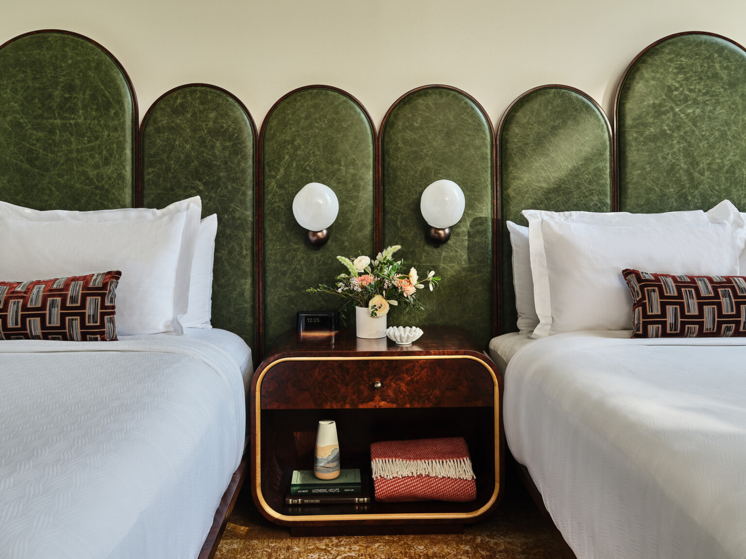 boutique hotel room design with emerald green leather headboard, midcentury modern design, nightstand and sconces