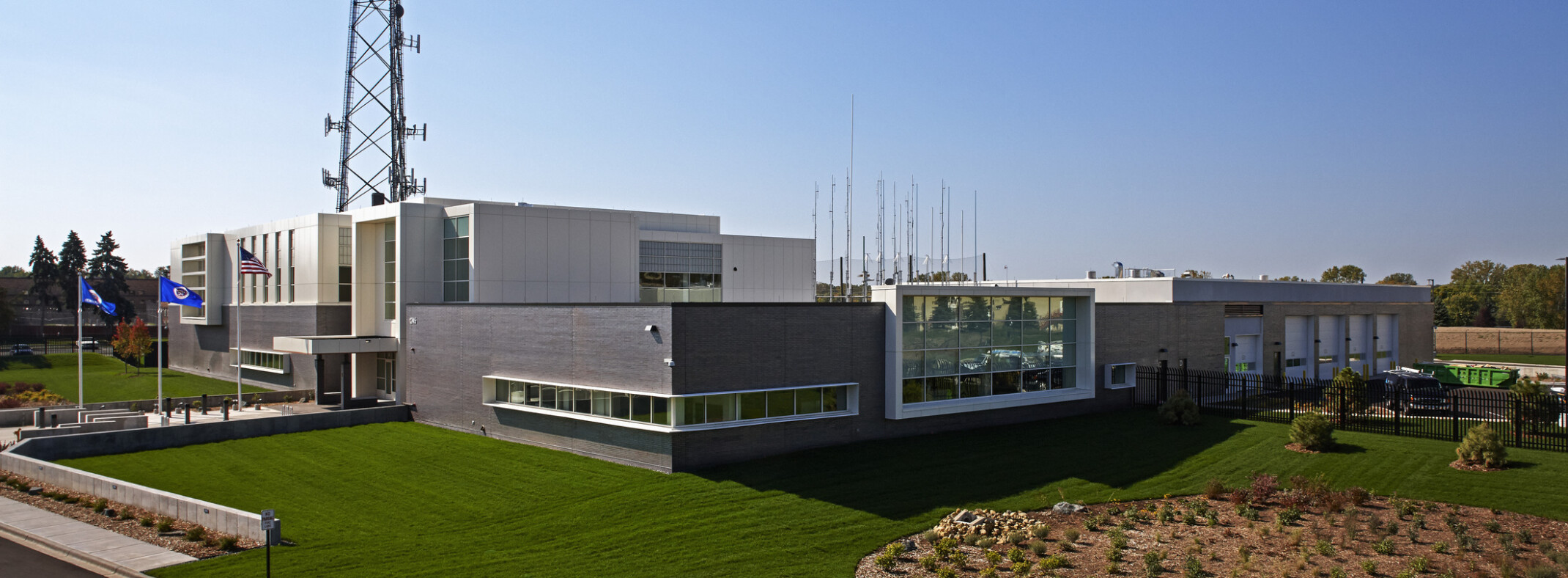 Emergency communications center exterior. Dark grey brick, white metal panels.