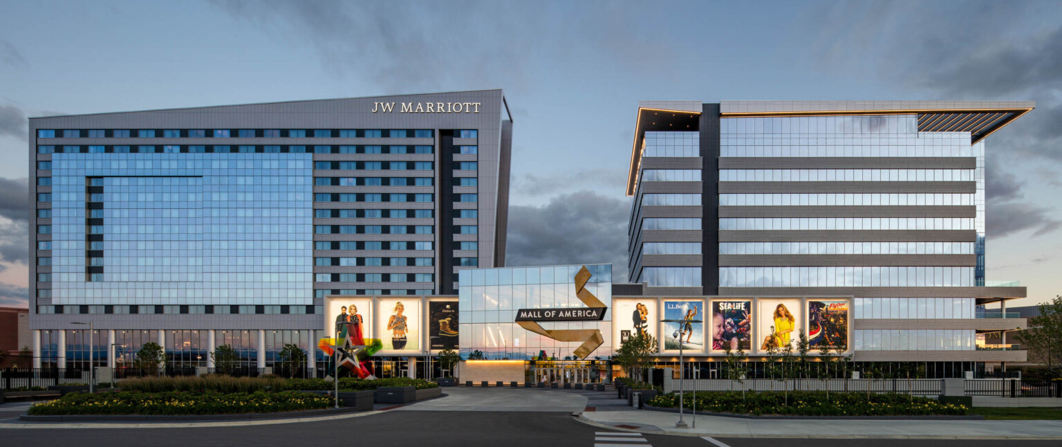 Mall of America entry with illuminated signage connecting 2 grey angled buildings. Left building labelled JW Marriott