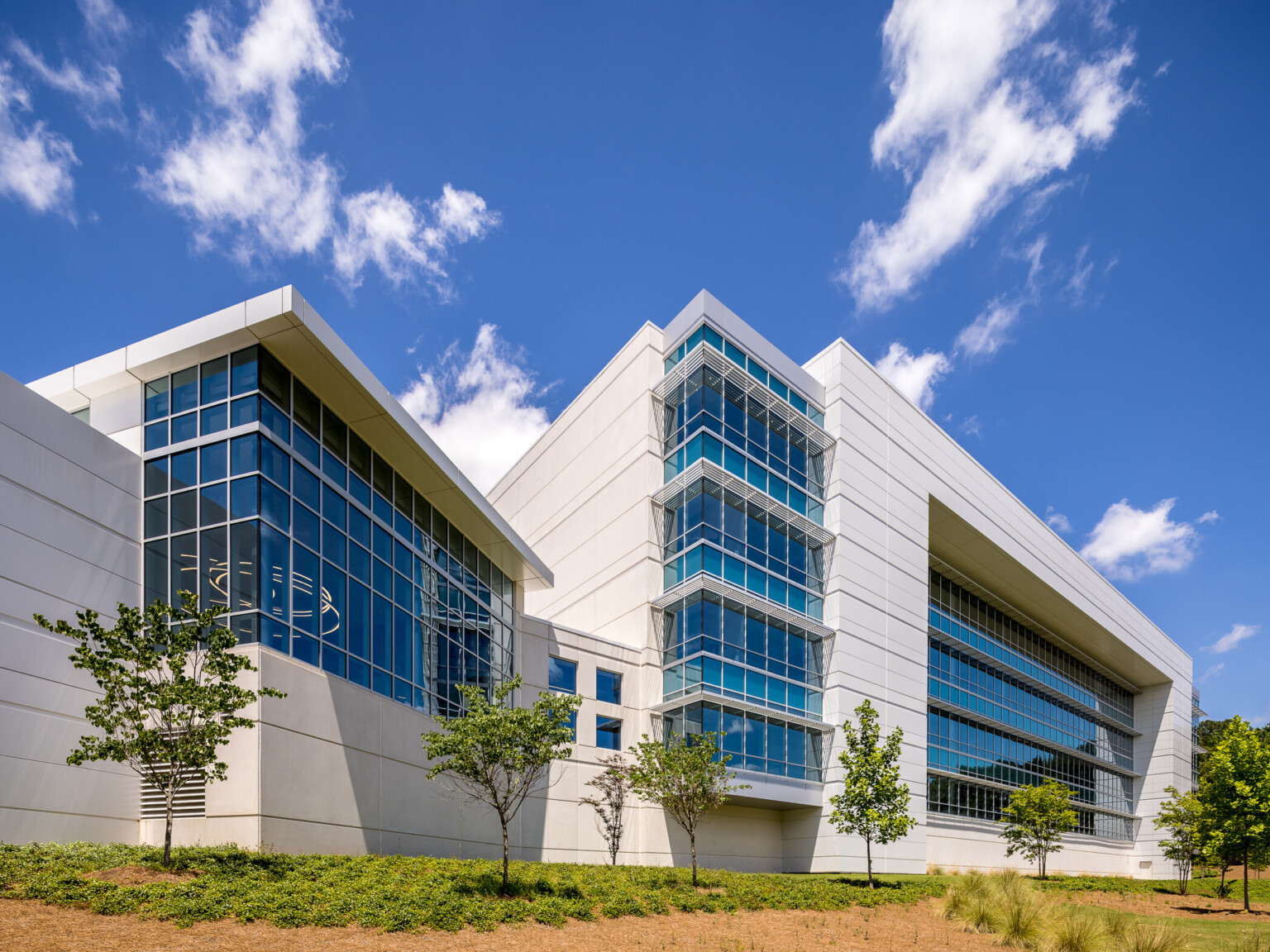 Modern multistory office building filled with windows covered by white awnings.