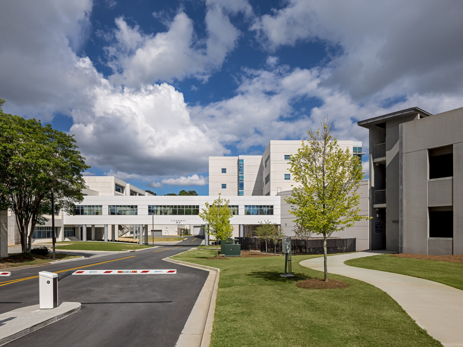 Darktop road surrounded by multistory office buildings with a walkway over the road