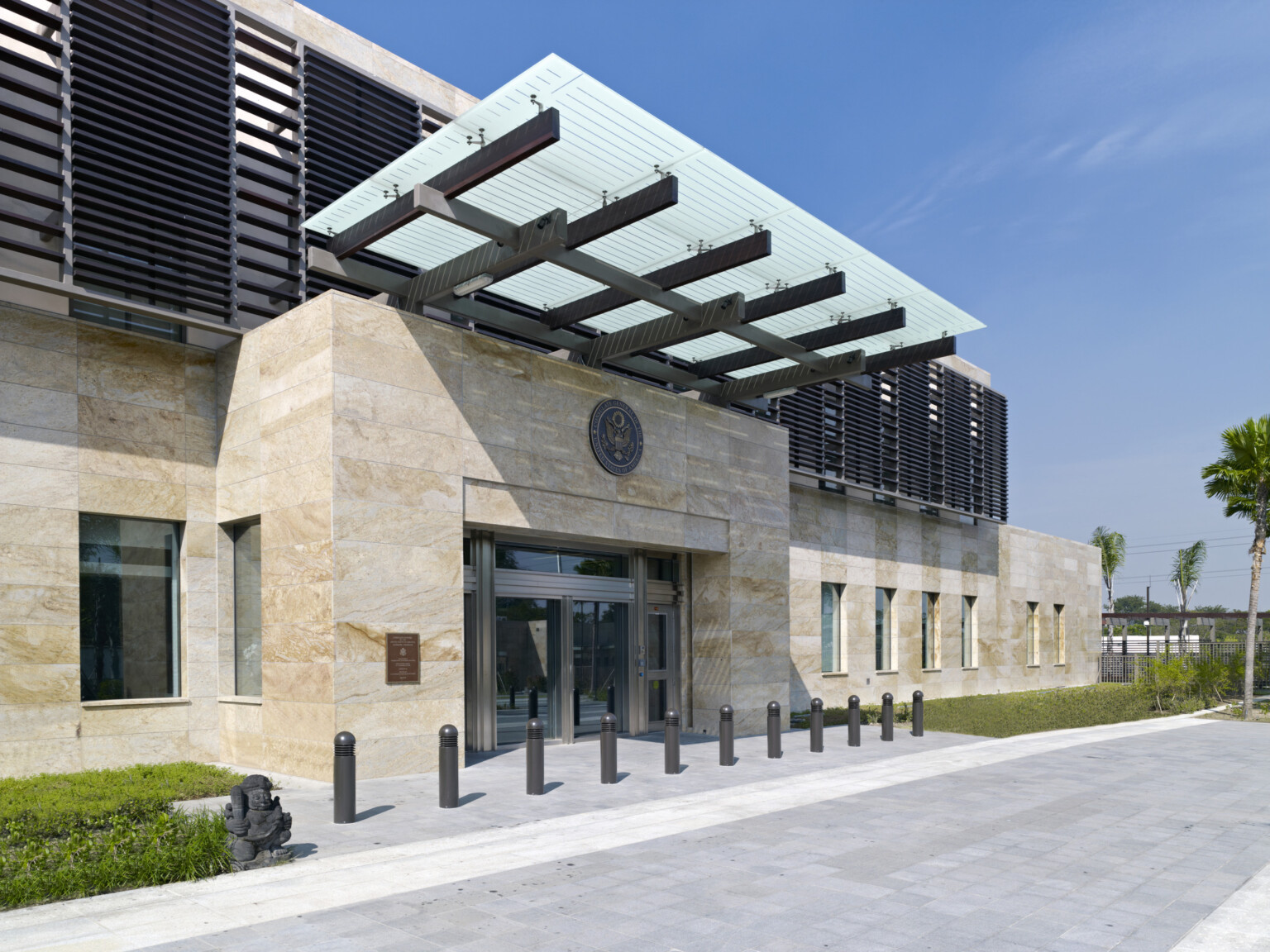 Exterior entrance of U.S. Consulate General, Surabaya, Indonesia. Off white tile exterior with metal louvered awnings