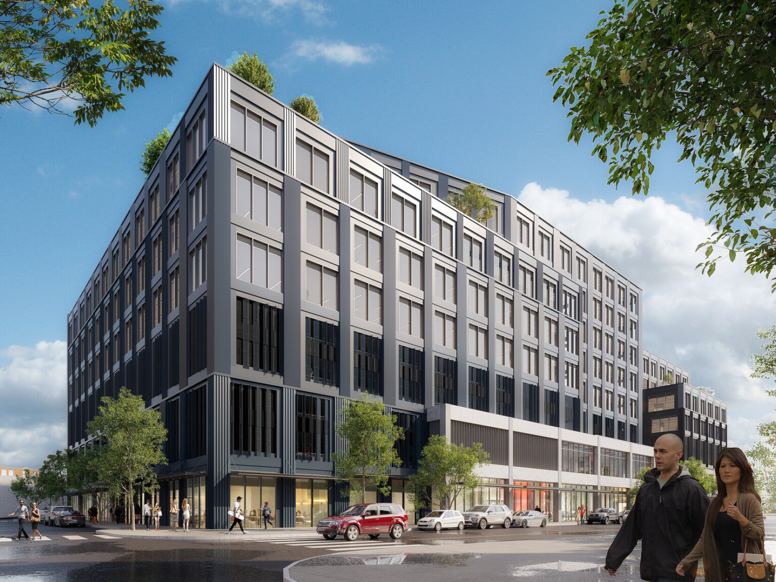 Corner view of grey multistory mixed-use building with large windows