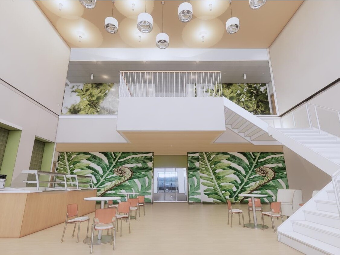 Indoor multistory dining room showing a mural with green leaves on the back wall with a modern staircase to the right