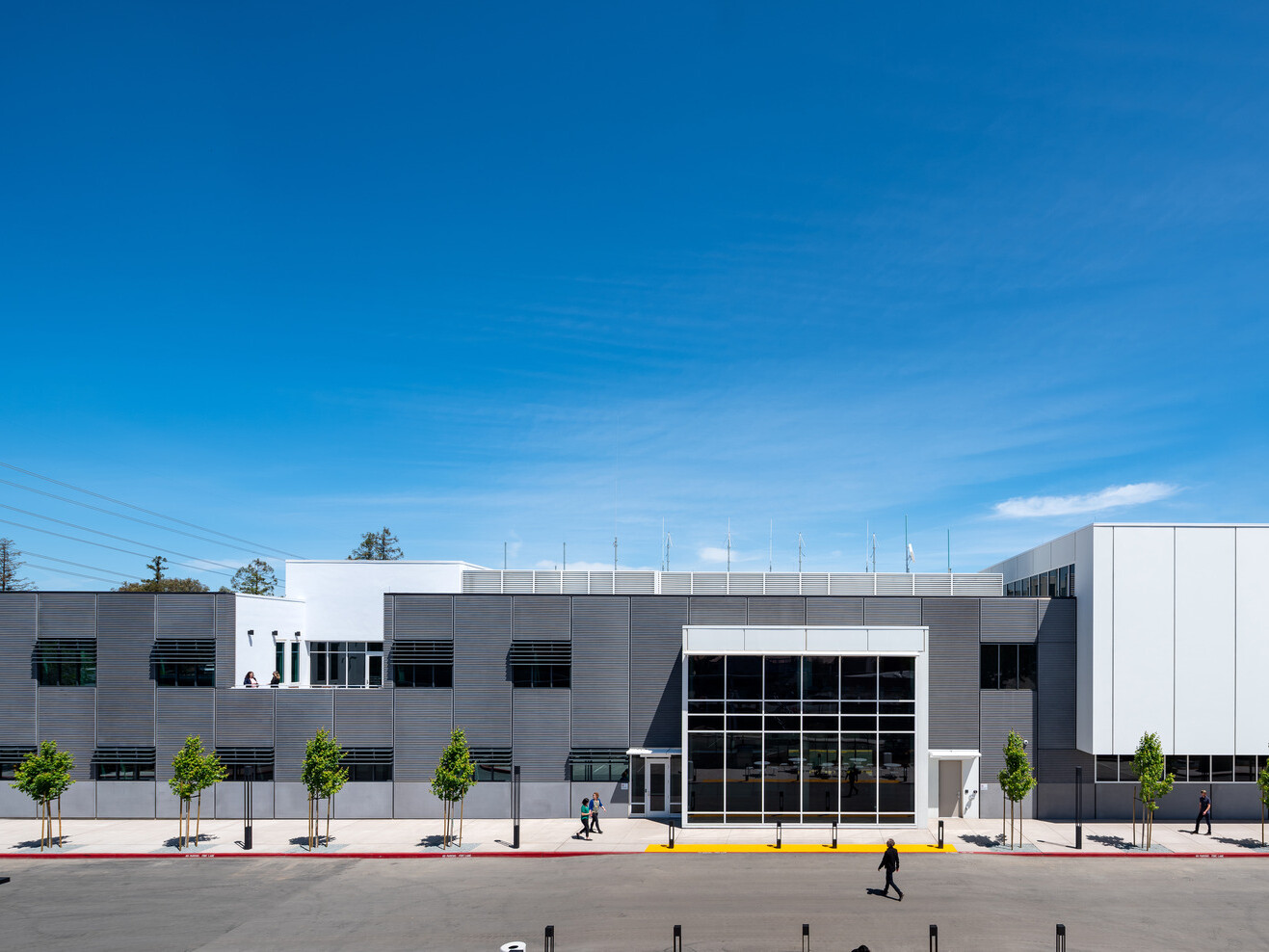 Modern grey multistory office building with white accents and large glass windows