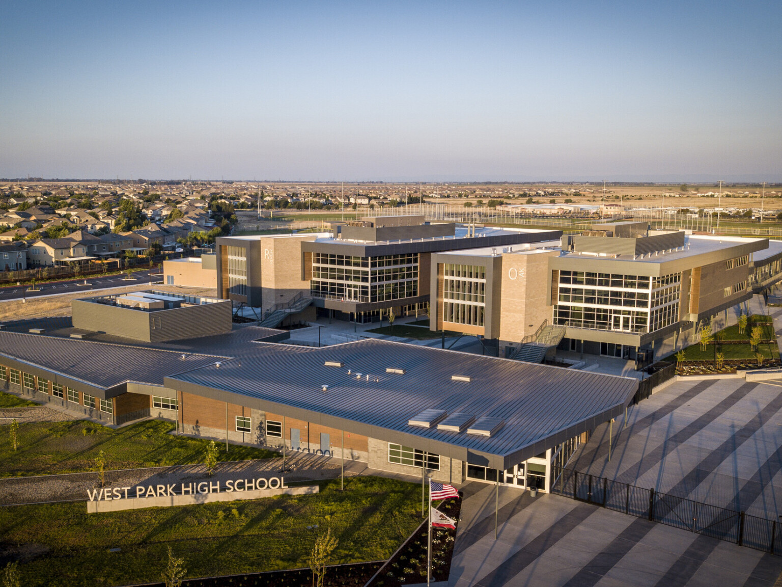 West Park High School aerial view. A brick and stone building with large windows and wrapped facade