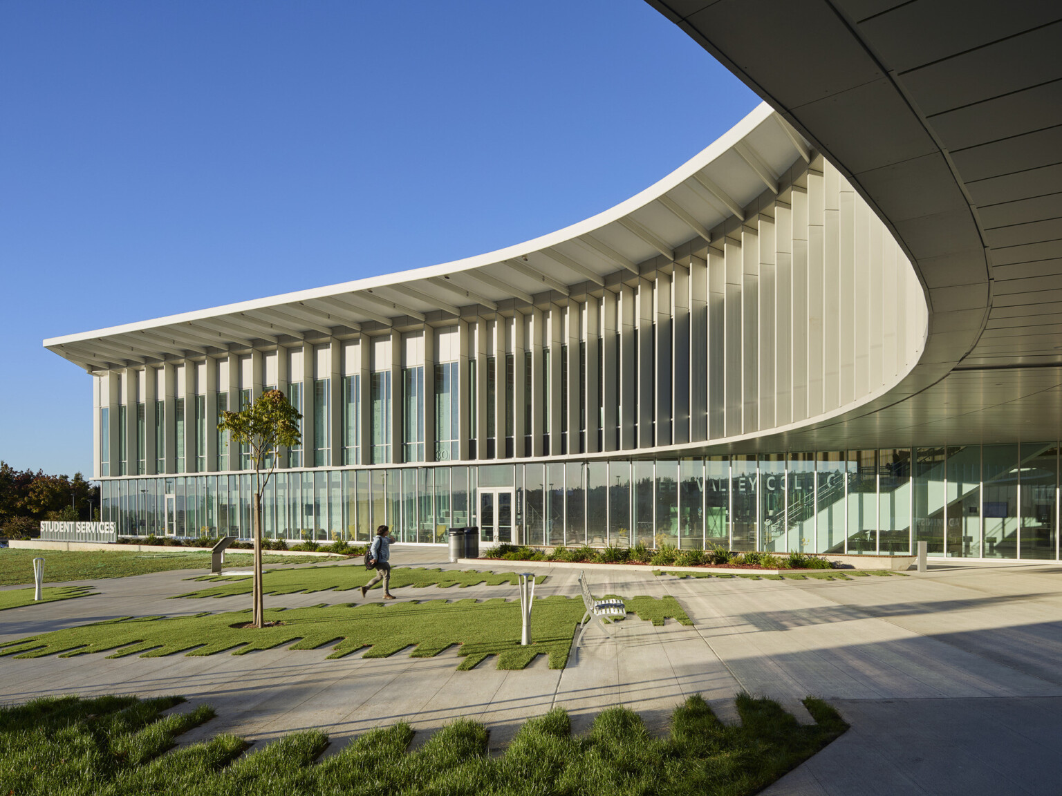 Multistory modern building with large glass panels and a curved roof