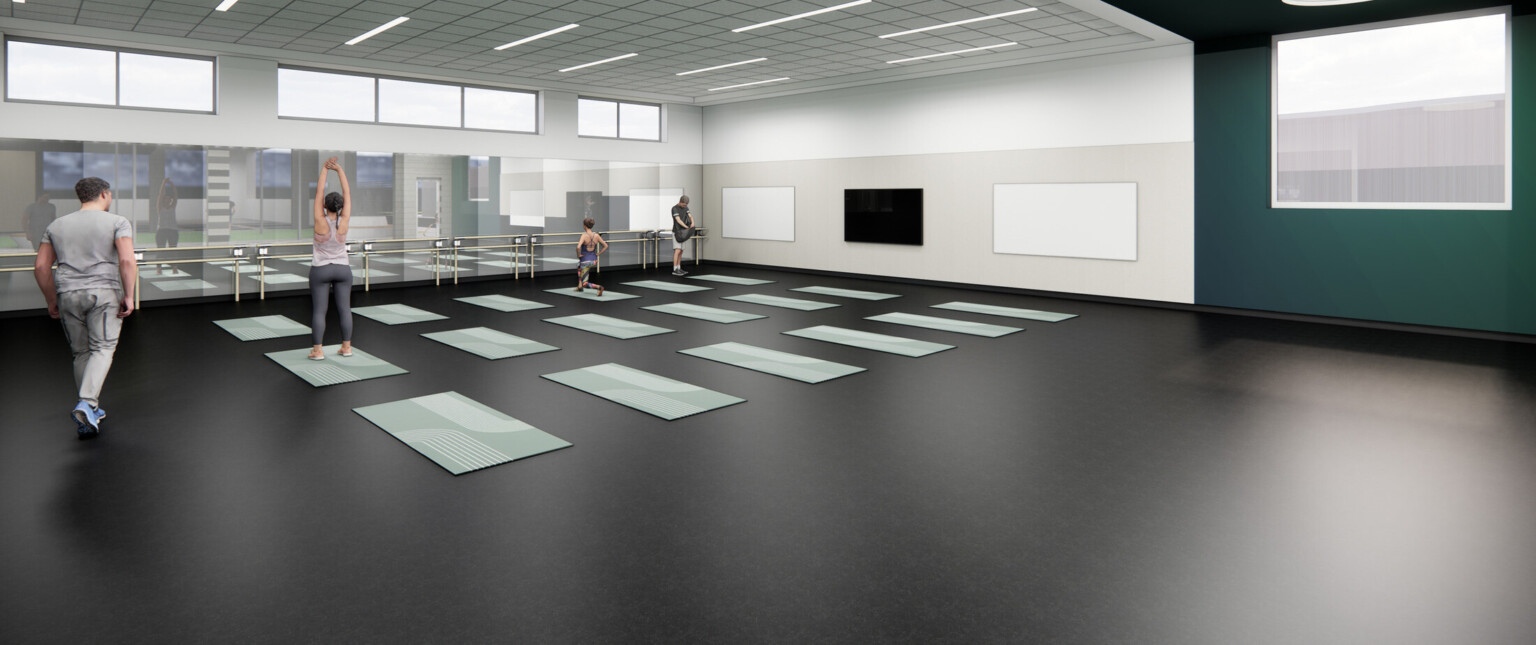 High school dance room with black floors, green accent wall, and a wall of mirrors