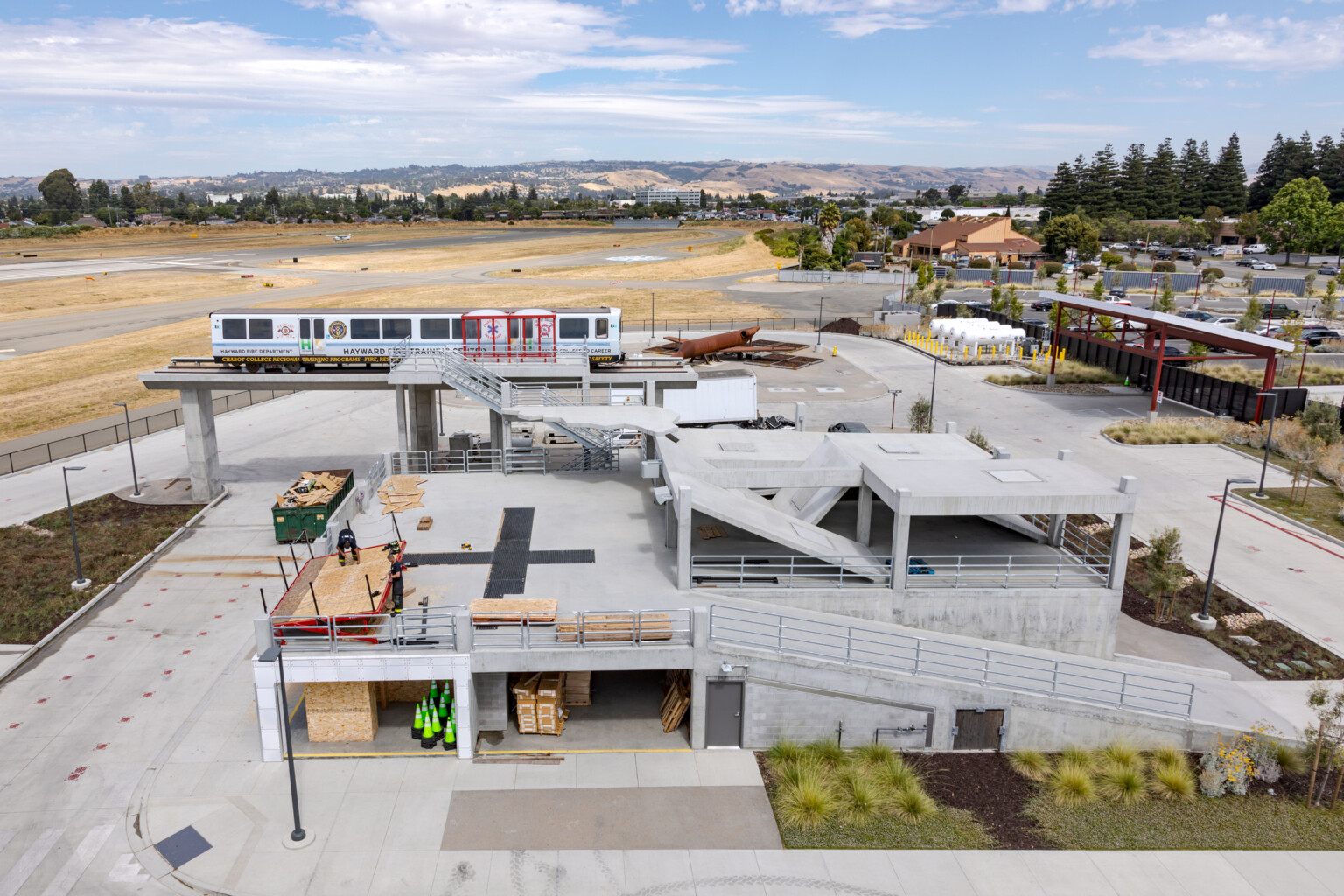 Aerial of the Hayward Fire Training facility showing a concrete building structure with mountains and trees in the background