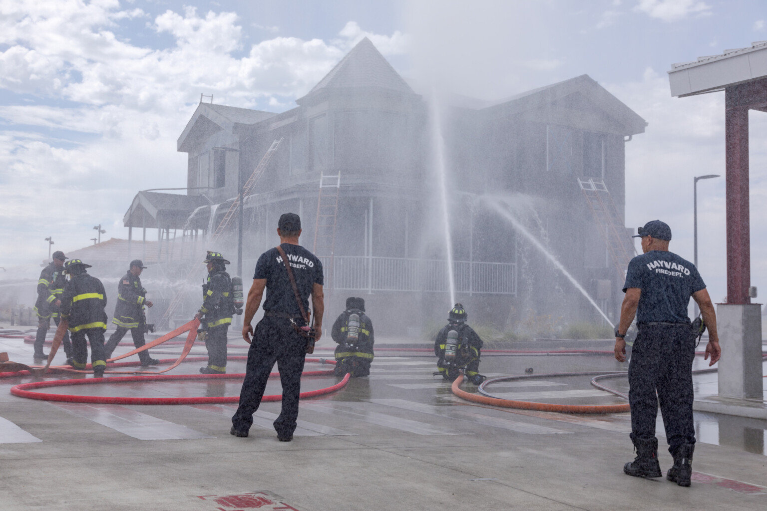 Hayward fire dept. spraying water on a Victorian style house.