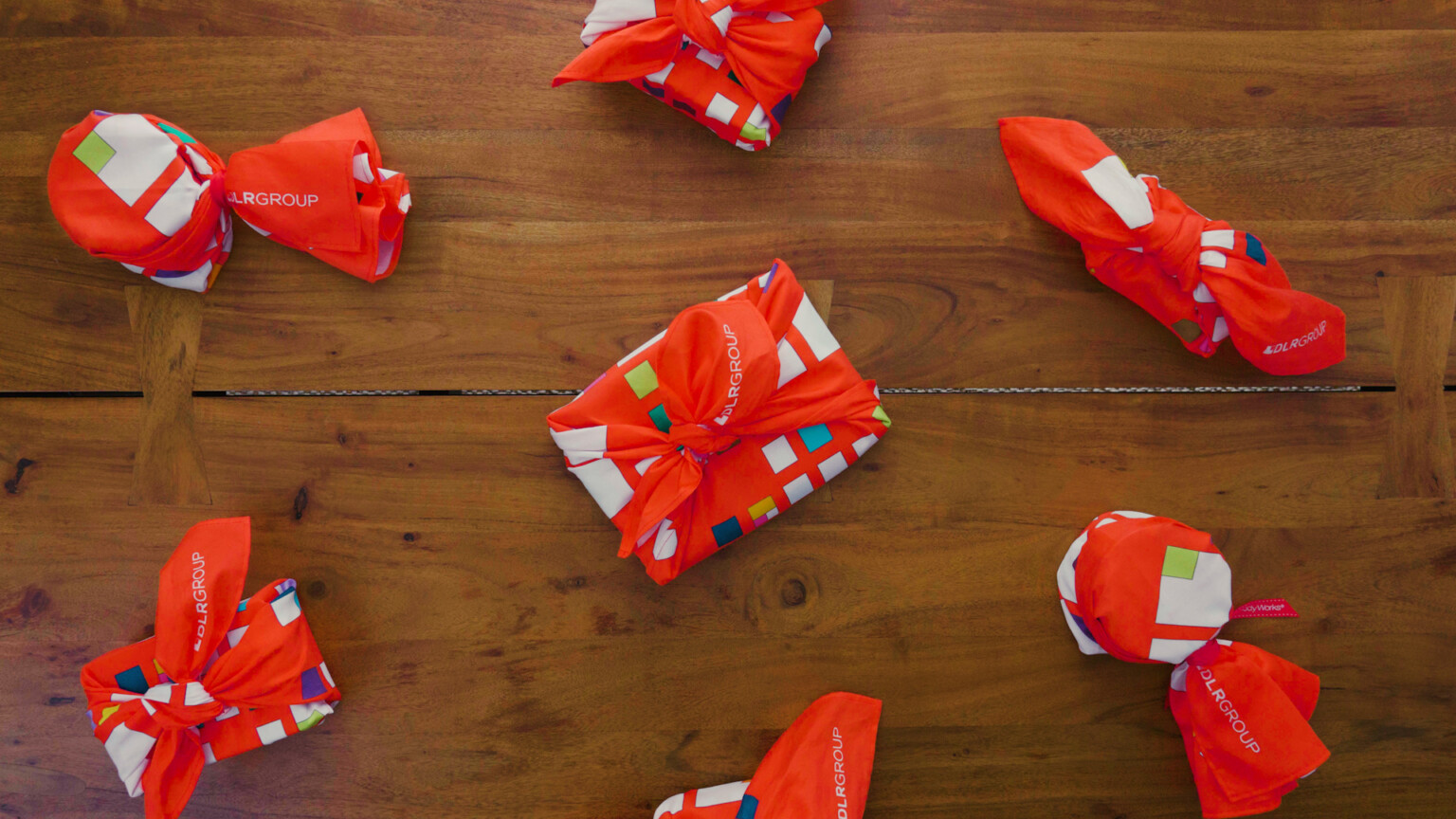 wrapping fabric, furoshiki, wrapped presents displayed on a wood table using a custom designed red wrapping fabric