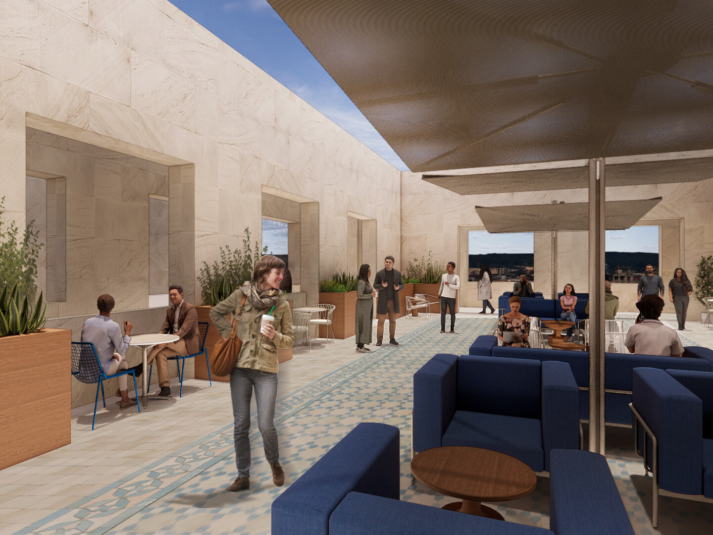 A courtyard or terrace area. The space features a combination of comfortable seating and dining areas, with blue sofas and wooden tables arranged under shaded canopies.