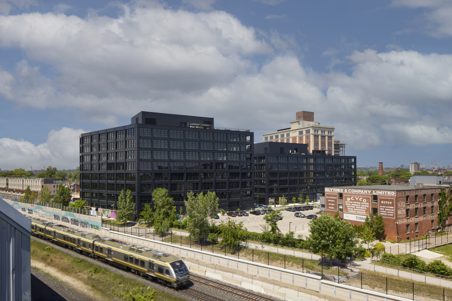 Aerial view of multiple black multistory buildings with a train running past