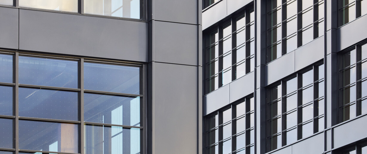 Aerial shot of the angles of black multistory buildings showing black framed windows