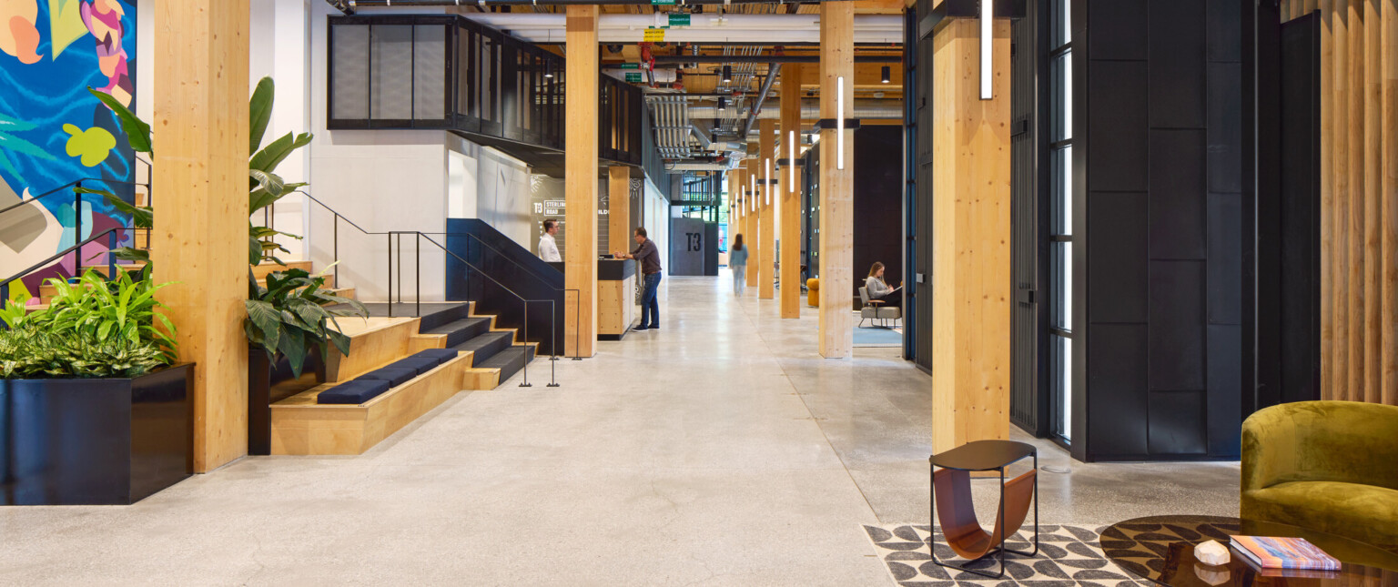 Office hallway with exposed wooden beams, colorful wall mural and black accents throughout