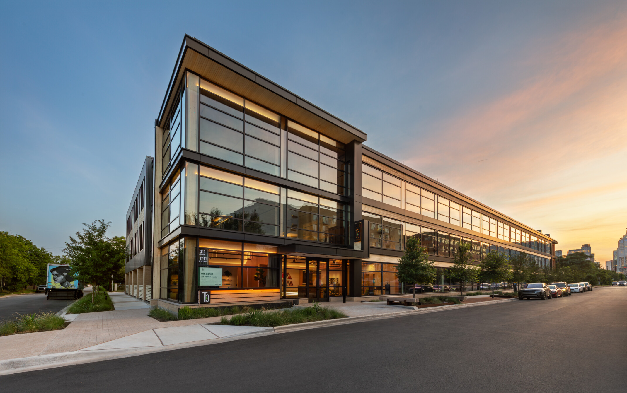 Mass timber midrise building with exposed wood, dark steel and reflective windows