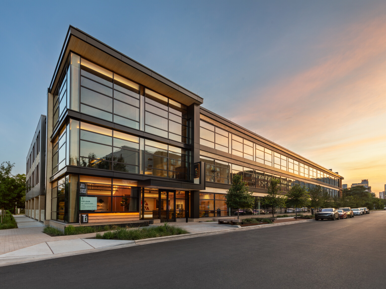 Mass timber midrise building with exposed wood, dark steel and reflective windows