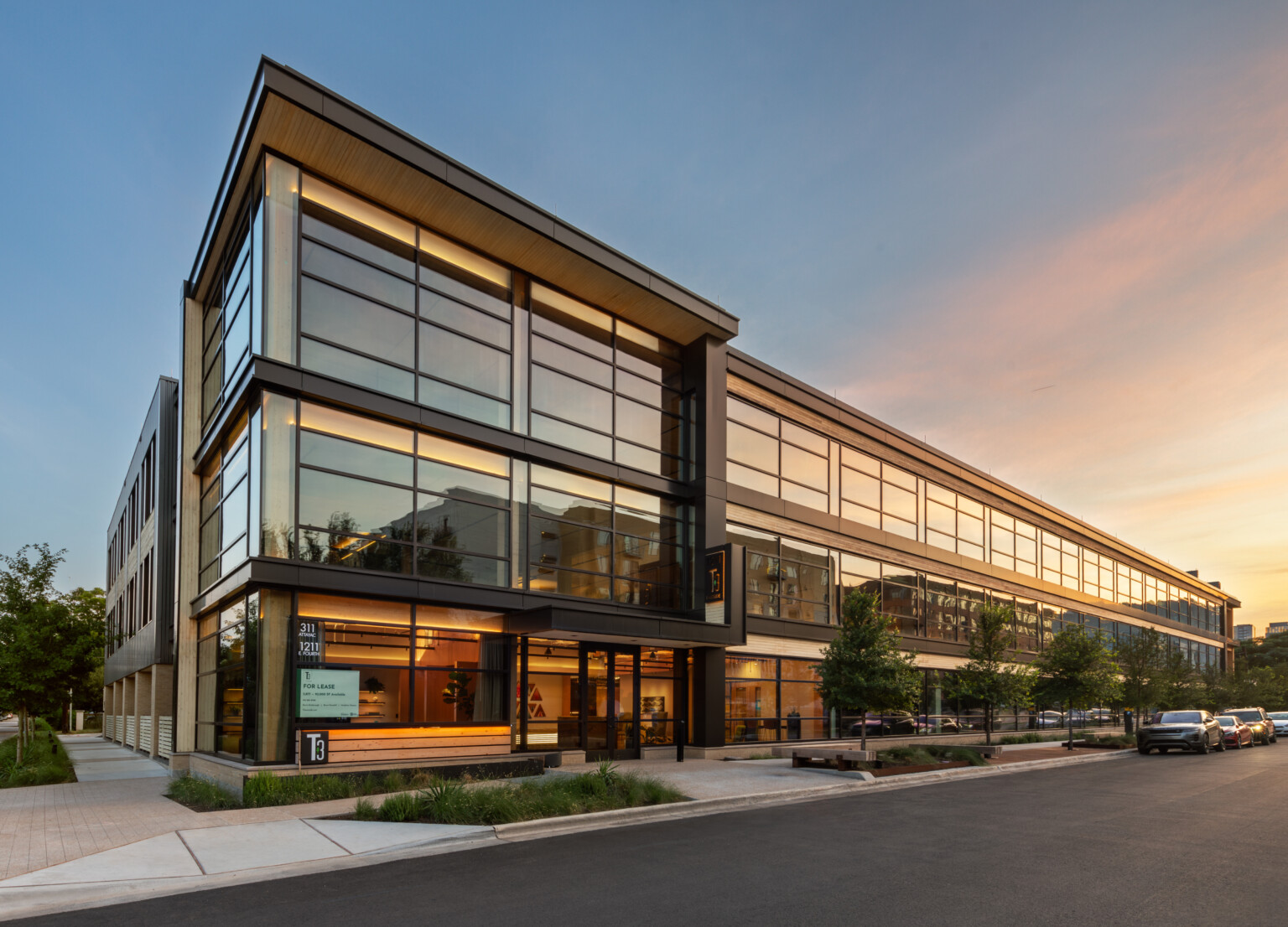 Mass timber midrise building with exposed wood, dark steel and reflective windows