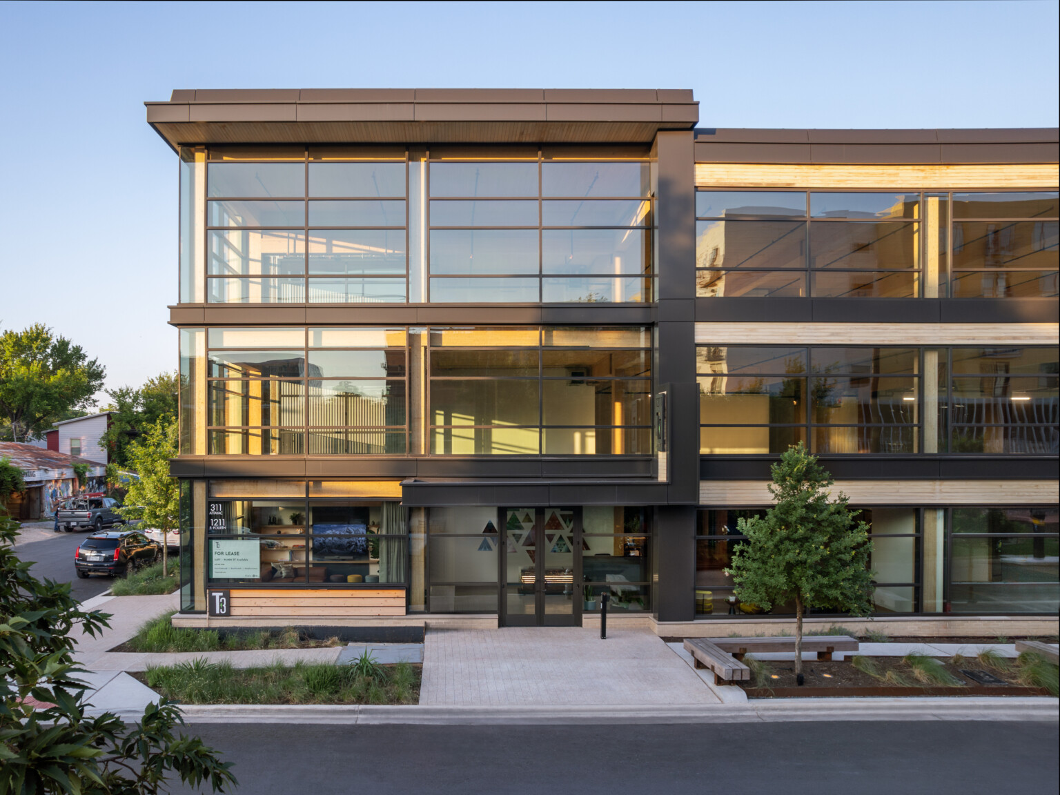 Mass timber midrise building with exposed wood, dark steel and floor to ceiling windows